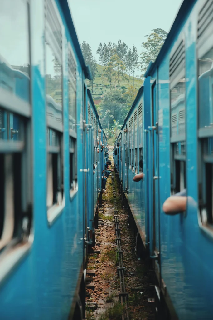 Scenic train ride through Sri Lanka hill country with blue train and lush green landscape